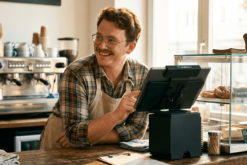 Gastronomin arbeitet mit einer iPad-Kasse mit integrierter TSE am Tresen ihres Cafés.