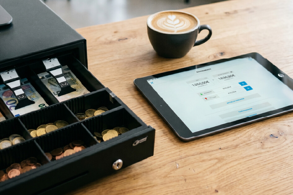 Offene Ladenkasse neben einem modernen Tablet-Kassensystem mit TSE