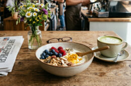 Functional Food Bowl mit Heidelbeeren, Chiasamen und Kurkuma in einem Café-Setting.