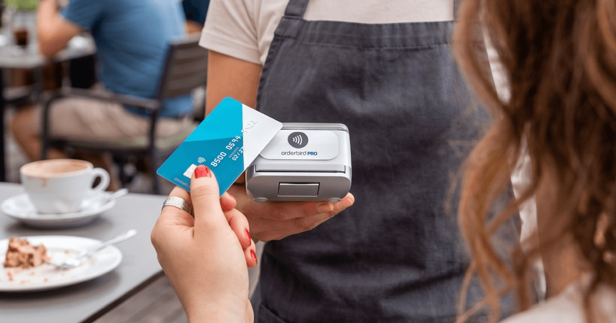 Kontaktlose Kartenzahlung an mobilem Terminal in einem Café